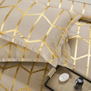Beige bedding set with gold geometric patterns on a bed.