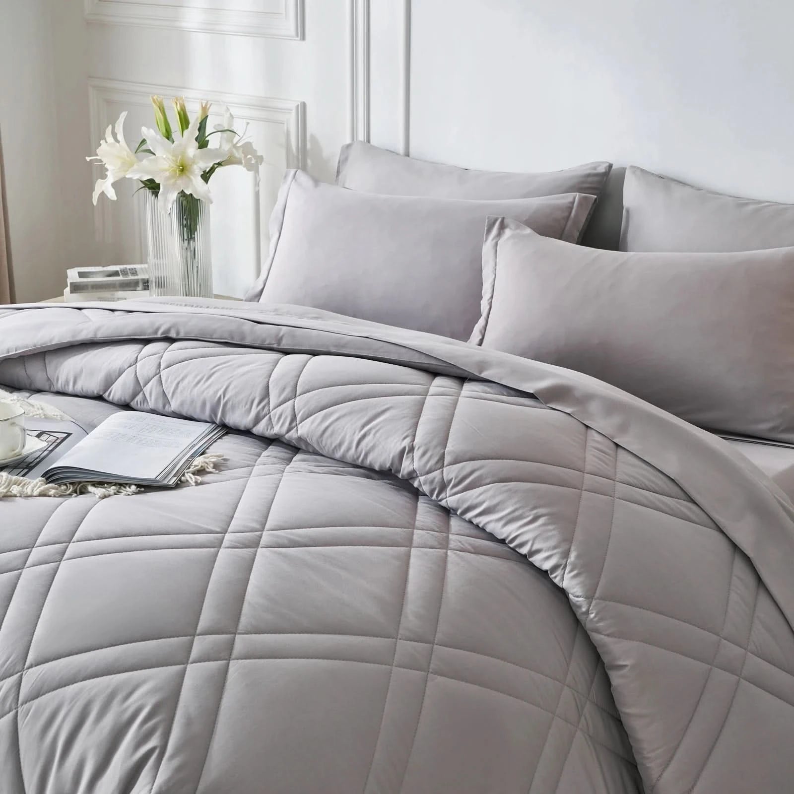 Gray quilted comforter set on a bed with pillows and a vase of flowers in the background.
Microfiber bedding set

Queen and King bedding

Soft comforter set

Modern bedroom decor

Machine washable bedding

Polyester comforter

Cozy all-season bedding

Brushed microfiber

Lightweight and warm comforter

Bedding set with pillowcases