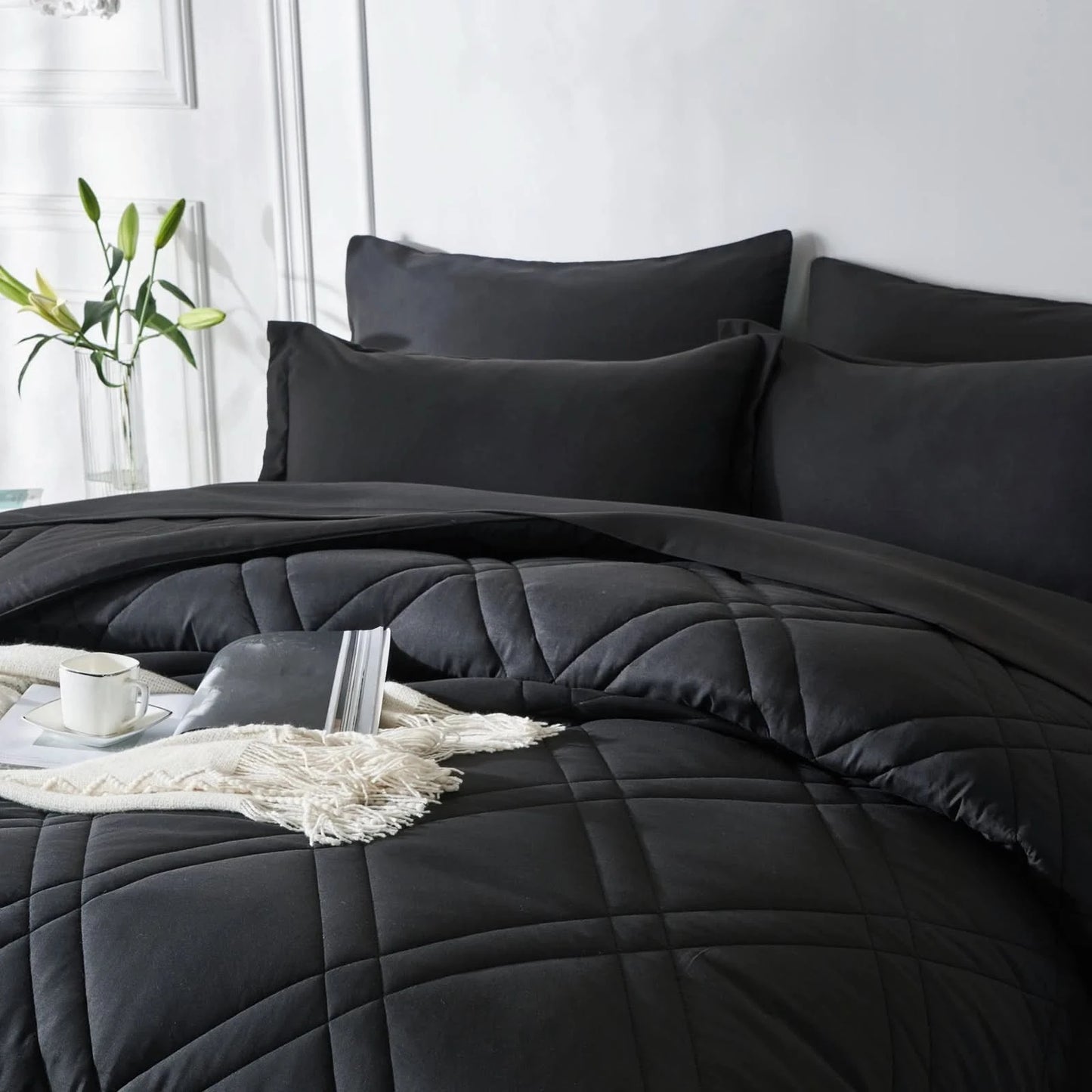 Black quilted comforter set on a bed with pillows and a side table in a 
Microfiber bedding set

Queen and King bedding

Soft comforter set

Modern bedroom decor

Machine washable bedding

Polyester comforter

Cozy all-season bedding

Brushed microfiber

Lightweight and warm comforter

Bedding set with pillowcases bedroom.