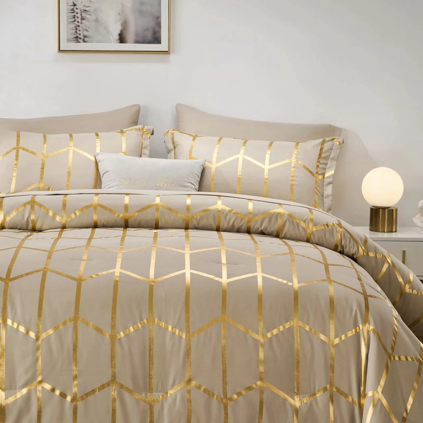 Beige and gold geometric patterned bedding set on a bed with a lamp in the corner.